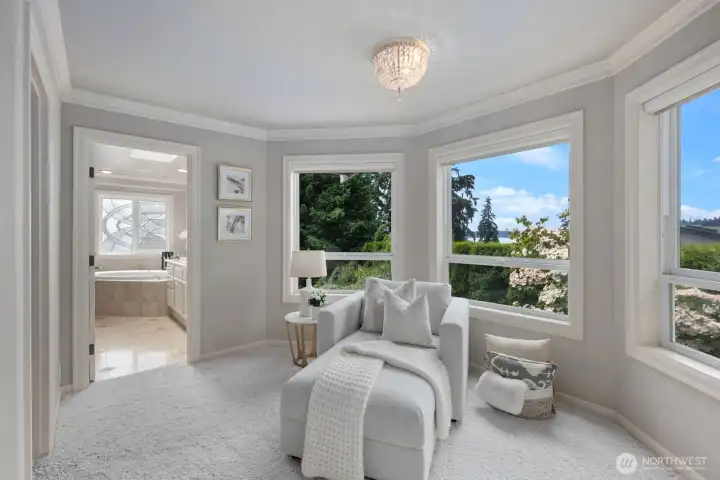 A serene primary suite with lake views, gas fireplace and a private sitting and dressing area. A serene primary suite with lake views, gas fireplace and a private sitting and dressing area.