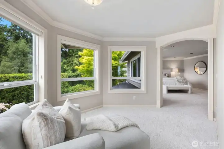 A serene primary suite with lake views, gas fireplace and a private sitting and dressing area. A serene primary suite with lake views, gas fireplace and a private sitting and dressing area.
