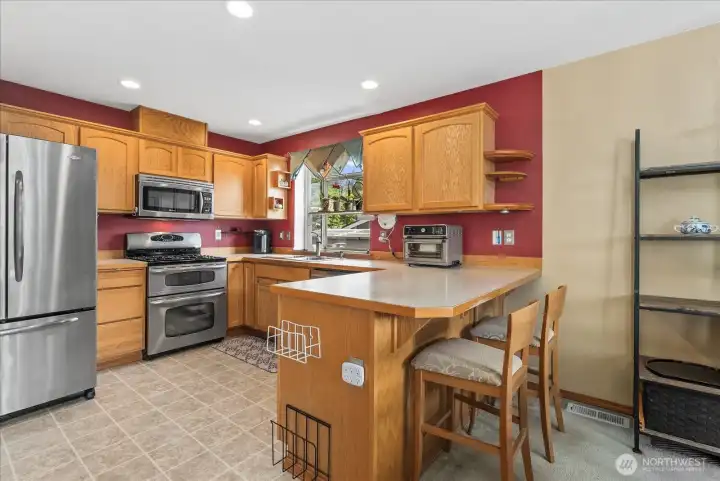 This kitchen features an open-concept layout, a convenient pantry closet, and all stainless steel appliances that are included with the home.