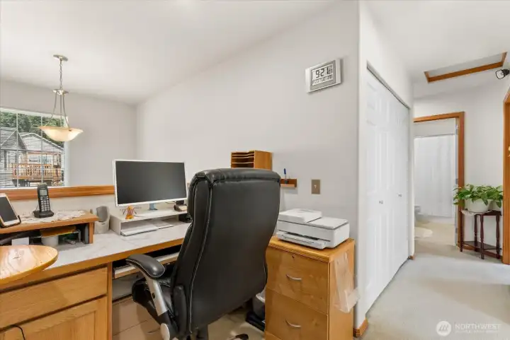 This loft area features high ceilings that create an open, airy atmosphere, making it the perfect dedicated space for a home office or a quiet study area.