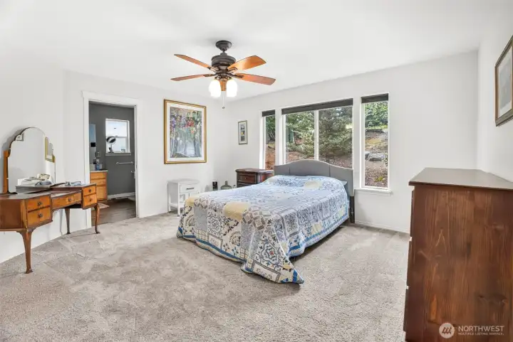 Main floor primary bedroom with ceiling fan, walk in closet and secondary closet, attached bathroom. Main floor primary bedroom with ceiling fan, walk in closet and secondary closet, attached bathroom.