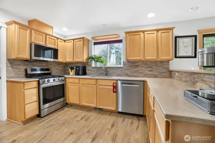 Kitchen with quartz countertops and stainless steel appliances. Kitchen with quartz countertops and stainless steel appliances.