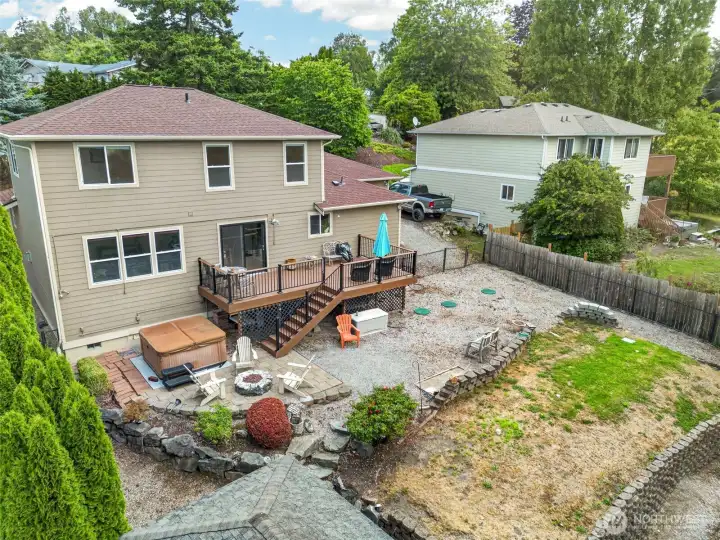 Back view of the house showing fully fenced backyard, firepit, hot tub. Back view of the house showing fully fenced backyard, firepit, hot tub.
