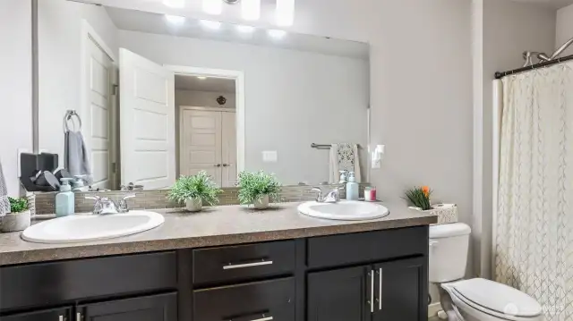 Full bath with dual sink vanity and tub/shower combo.