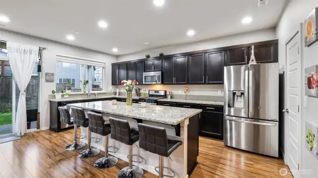 Just off the kitchen, sliding doors lead to a covered patio overlooking a fully fenced backyard—perfect for al fresco dining, summer barbecues, or relaxing under the stars.
