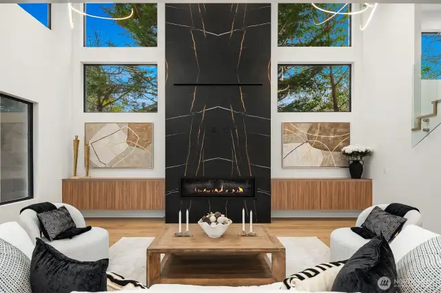 Light filled living room with 20' ceilings and gas fireplace.