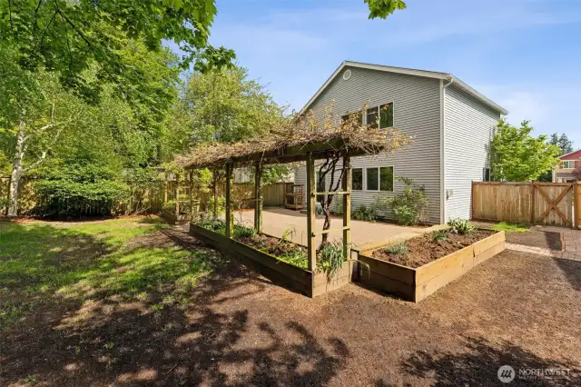 Grass area plus garden beds. Space for additional storage sheds.