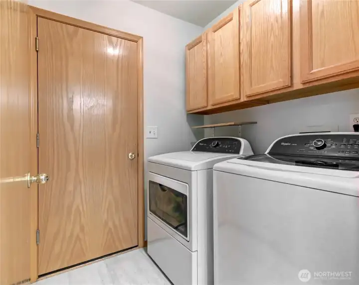 Laundry with storage leads to the garage