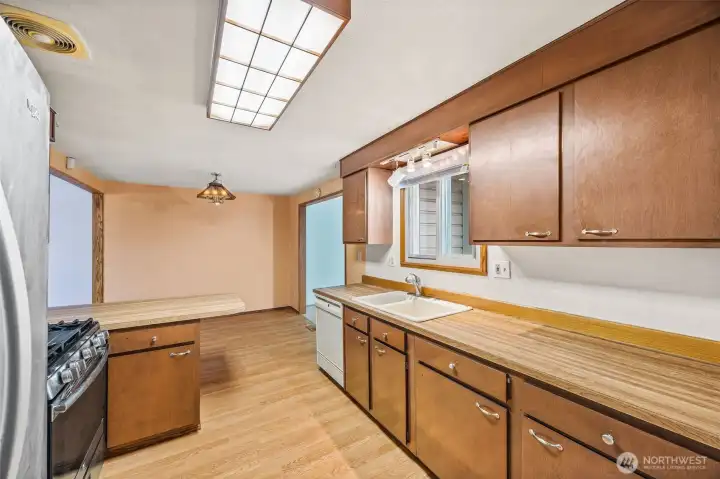 Generously sized kitchen with abundant counter space, gas stove, and functional layout — ideal for cooking and entertaining. Great opportunity to add personal updates and build instant equity.