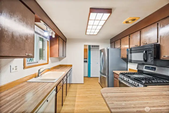Functional kitchen with plenty of cabinet storage and counter space, conveniently located off the dining area — ready for your personal touches.