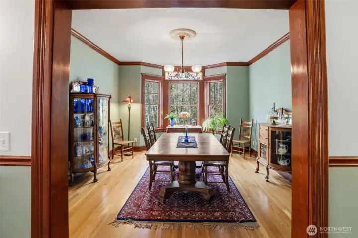 A formal dining room with vintage lighting and stained glass window accents is the perfect place to celebrate holidays and enjoy guests. Beautiful hardwood flooring too.