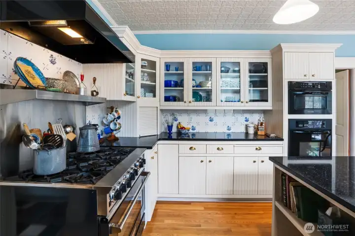 This Victorian inspired kitchen includes real hardwood flooring, tile backsplash, custom cabinetry, and a Blue Star gas cooktop.