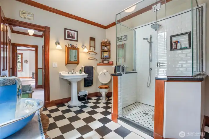 A guest bath is situated between three of the bedrooms on the second floor and includes a large walk-in shower with subway tile and fun checkered flooring.