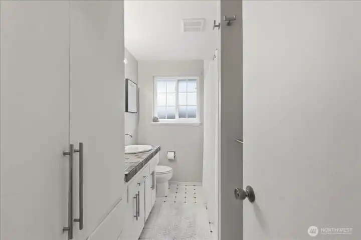 Beautifully remodeled full bath has custom tile and handsome fixtures.