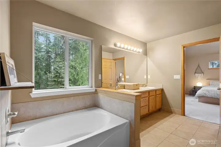 Primary en-suite with large soaking tub, double vanity and 2 walk in closets.
