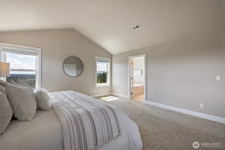 Expansive primary suite with multiple windows bringing in natural light