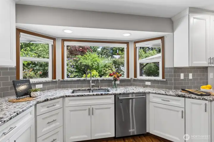 Large windows showcasing the home’s mature landscaping and peaceful outdoor setting.