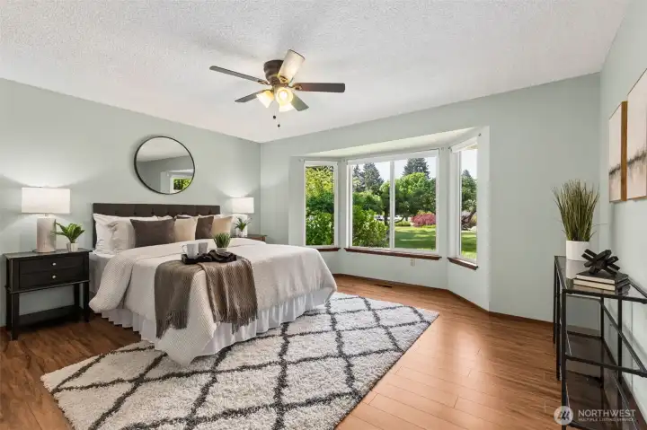 Primary bedroom windows overlook the blooming apple trees in the front yard.