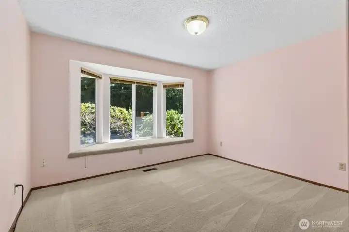 Bedroom featuring a charming bay window bench with built-in storage.