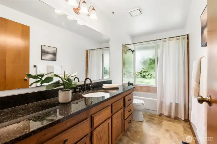Hall bathroom with tub/shower combo and generous counter space.