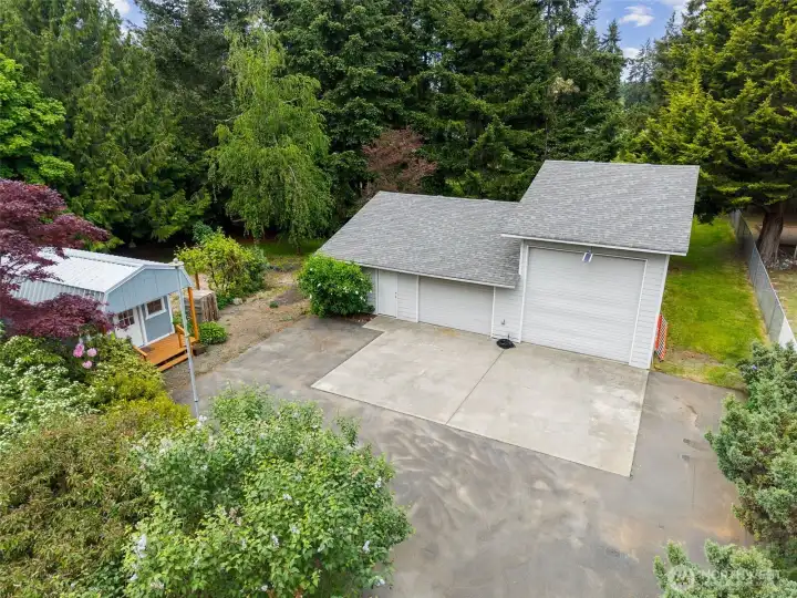 Oversized powered shop with RV bay, workshop space, built-in cabinetry, work surfaces, and shelving that stays. Exterior water spigot plus future water conduit already installed for potential expansion possibilities. Current owners comfortably stored a 25ft camper with additional overhead and side clearance.