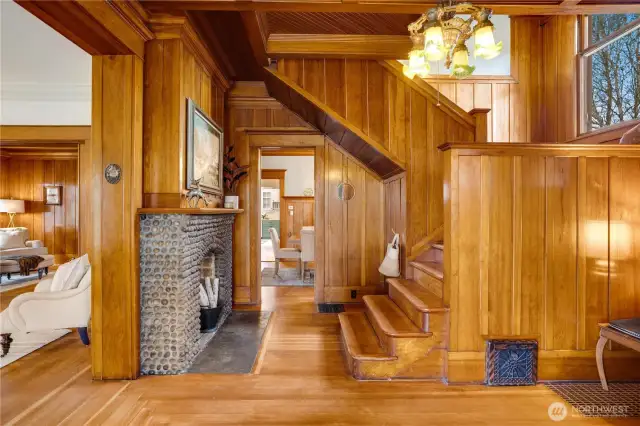 Original Washington-grown hemlock millwork rises from baseboard to board-and-batten paneling, from crown molding to the beamed, herringbone ceiling while original fir floors gleam below. Every direction calls with interest. Where to start? Go straight ahead into the formal dining room? Up the stairs toward the window seat? Let's take a left into the parlor to begin.