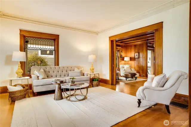 The front parlor offers light and elegance with windows facing south and east. Look out across the wraparound porch to the neighborhood trees and activity of people going to and from nearby schools.