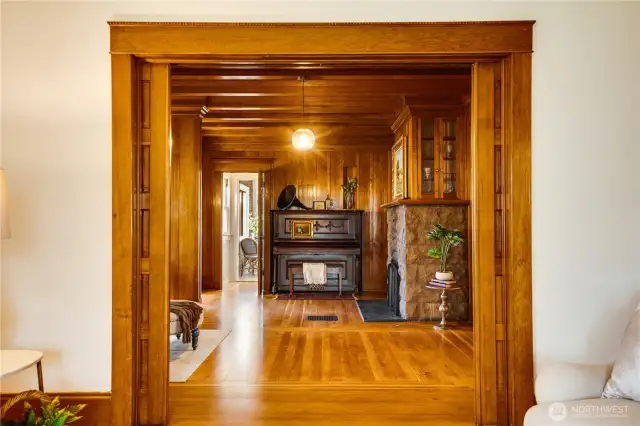 A cased opening—complete with a set of working pocket doors—connects the front parlor to the living room and den beyond. Slide them open to glimpse light coming through all the way from the kitchen at the back of the house, or closed to keep the focus in one place. Notice the design of the fir floors throughout. Rather than all running parallel to one another, you'll see "stepped" borders sometimes referred to as a "log cabin corners."