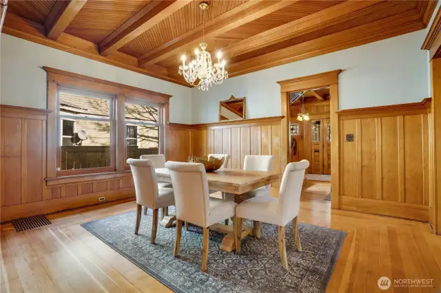 Move from the central living room into this formal dining room where the herringbone ceiling continues. Board-and-batten wainscot is topped with plate rail trim for displaying treasures. A doorway leads in from the reception hall, and another opens to the back hall toward the 3/4 bathroom and the kitchen.