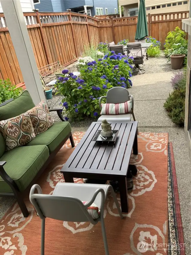 Backyard walking path to covered patio with gas fireplace and to sliding door. Perennials are blooming every year.