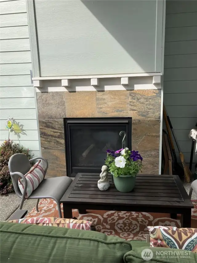 Outdoor fireplace under covered patio.