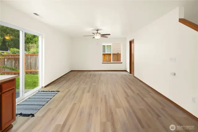 Great room off kitchen with a ceiling fan and light - powder room on the right.