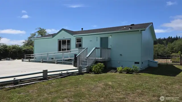 Front view with large concrete parking area