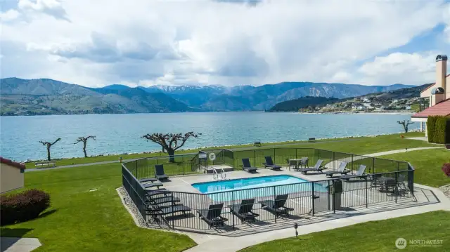 The community boasts 900 ft of waterfront with sandy beach and on-site security. Amenities include dock, boat launch, 5 pools, hot tub, 6 tennis courts, gym, racquetball court, game room, playground, sport court, volleyball court, EV charging, walking path, and private clubhouse for owners.