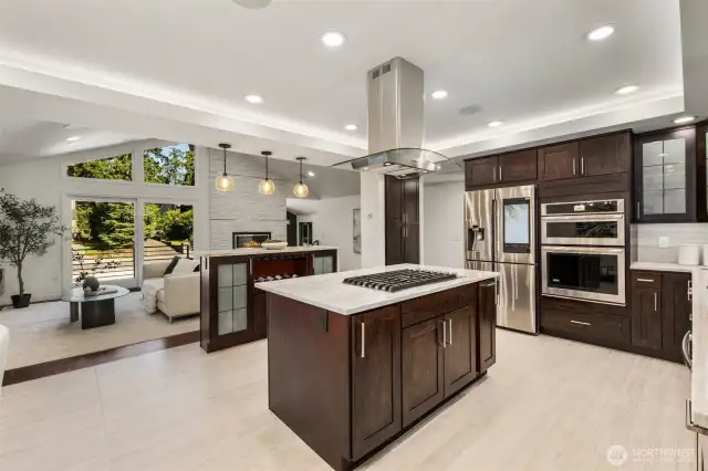 Quartzite counters and rich wood cabinetry bring depth, while the double ovens, gas cooktop, and built-in fridge offer ease at every turn.