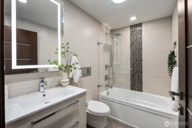 Serene guest bath with deep jetted soaking tub and sleek tilework