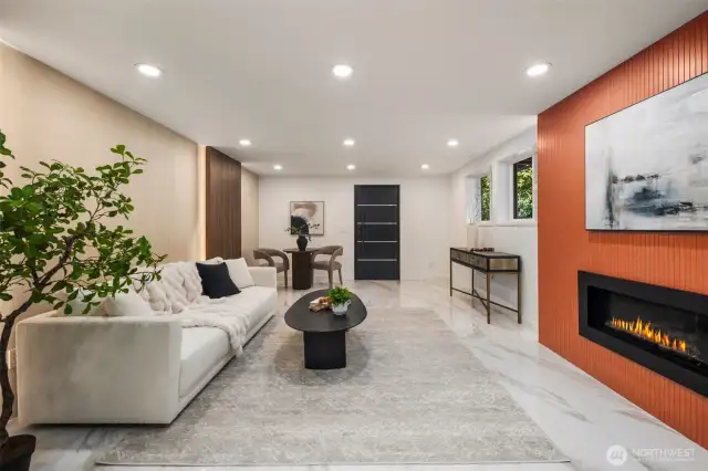 Luxury tile flooring leads to a signature gas fireplace framed in Dekton.