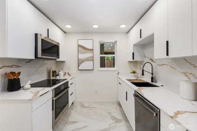 Quartz countertops with full-height backsplash and stainless appliances deliver both style and performance in this brand new kitchen.
