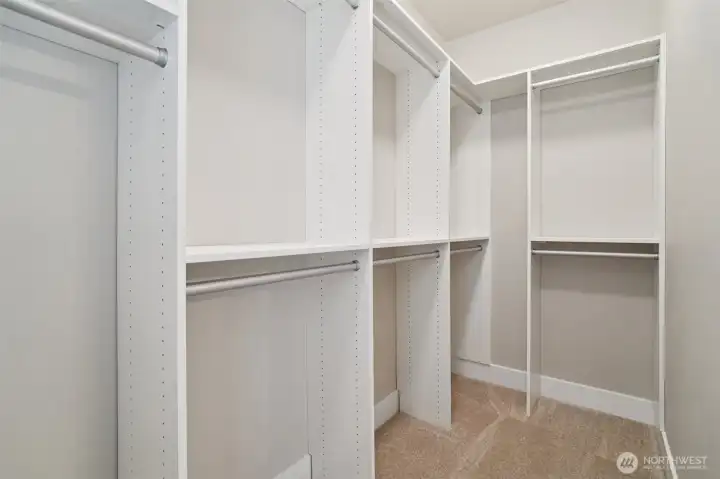Primary walk-in closet features upgraded closet system
