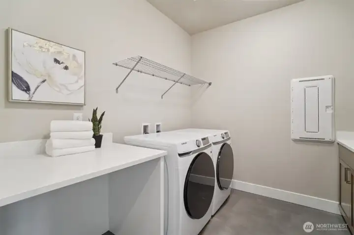 Second floor laundry room with built-in cabinetry and extra folding space