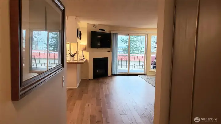 view from bedroom hallway to gas fireplace and gorgeous engineered hardwood flooring.