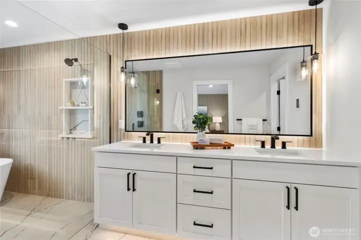 This primary bathroom is a stunning blend of elegance and modern design, featuring a double-sink vanity with sleek black accents and warm wood textures. From the glass-enclosed shower to the freestanding tub and ambient lighting, every detail contributes to a spa-like retreat that’s both functional and luxurious.