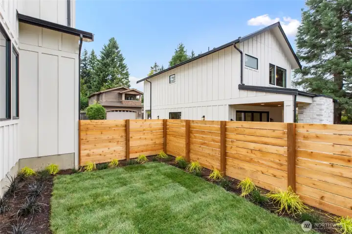 Private, polished, and framed by clean lines—this side yard offers a serene green escape with manicured beds and modern fencing.