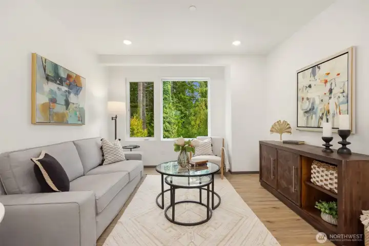 Through the living room’s wide window, lush forest views create a private, tucked-away feel.