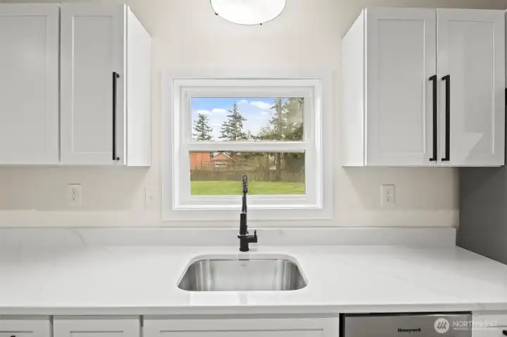 Kitchen sink in additional living space looks out to the peach tree and back yard.
