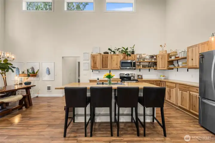 Custom wood cabinetry, open shelving, and expansive prep space create a functional yet inviting gathering space designed for everyday living and entertaining alike.