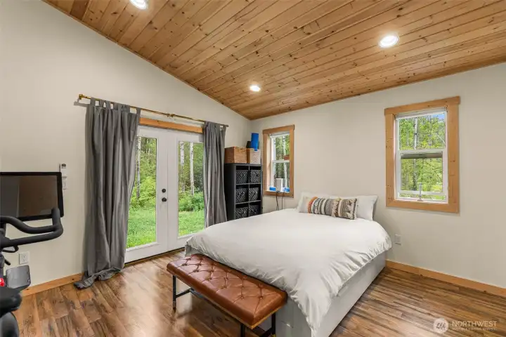 Warm wood ceilings and natural trim create a calming mountain-modern atmosphere in this peaceful bedroom retreat