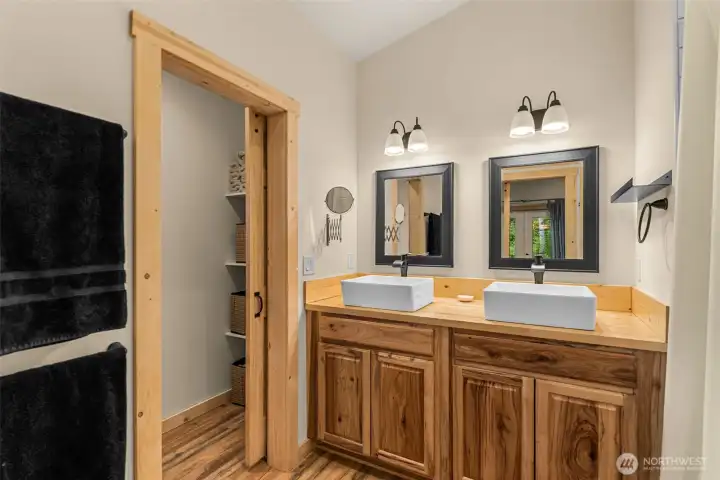 The primary bath continues the home’s warm mountain-modern aesthetic with rich natural wood cabinetry, clean lines, and thoughtfully selected finishes throughout