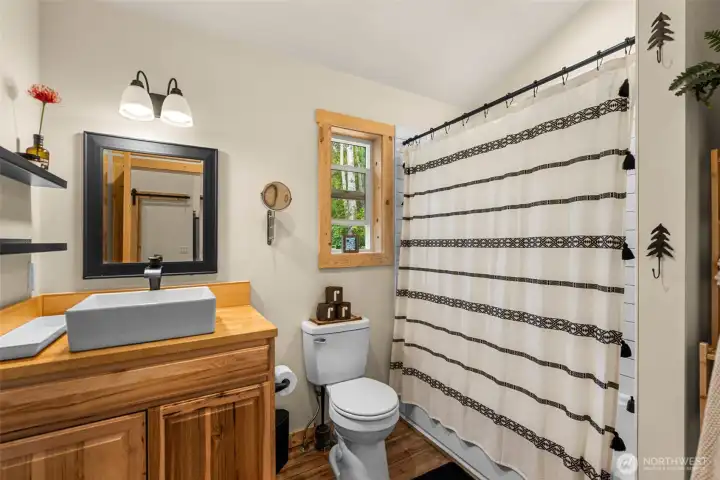 Clean lines and warm natural finishes define this thoughtfully designed bath, where rich wood cabinetry and modern vessel sinks create a refined mountain-modern aesthetic.