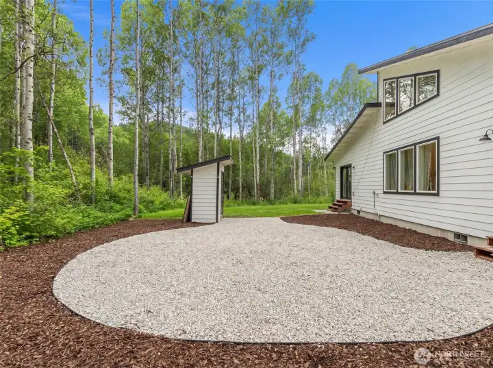 The backyard setting creates a true sense of retreat, opening directly into a peaceful grove of aspens and natural forest landscape that feels both private and immersive.